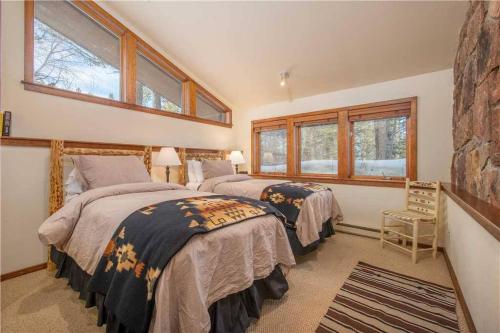 提顿村Bray House - Ski-in Ski-out family home的卧室设有两张床,带两个窗户