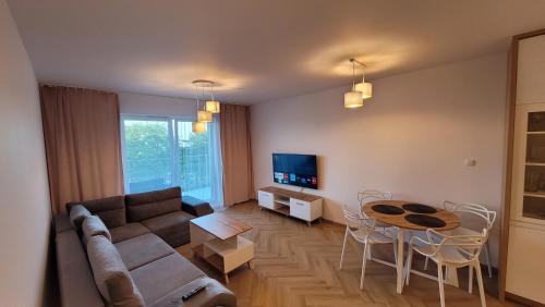 维尔卡瑟Apartament Niegocin Garaż Basen Plaża Giżycko Wilkasy的客厅配有沙发和桌子