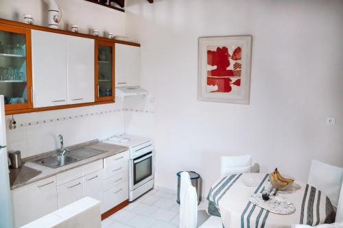 圣尼古拉奥斯Pagiantes的厨房配有白色橱柜、水槽和桌子