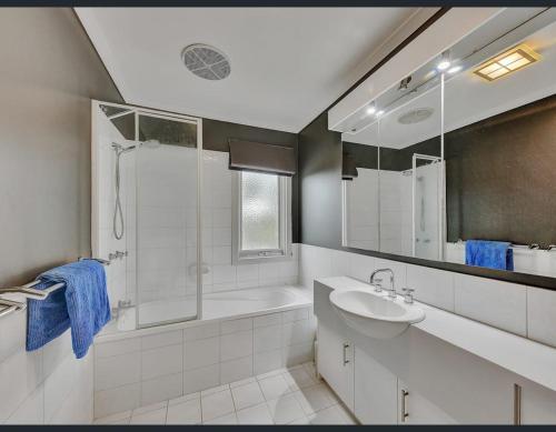 穆尔瓦拉Golf Views Apartment的白色的浴室设有水槽和淋浴。
