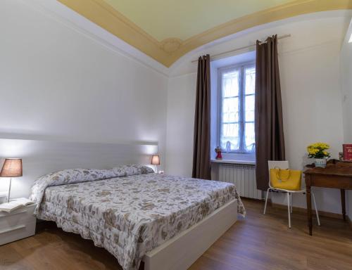莱科Le Montagne - Le Casette di Osvaldo的一间卧室配有一张床、一张书桌和一个窗户。