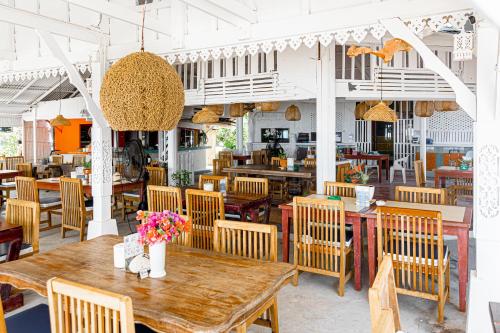 曾蒙海滩湾海滩度假酒店的餐厅配有木桌和椅子