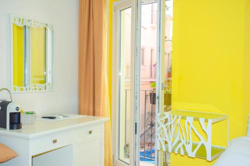 格拉维纳普利亚B&B Santa Sofia的一间卧室设有黄色的墙壁和镜子