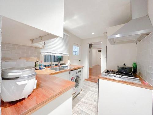 悉尼Pyrnmont Terrace & Townhouse的白色的厨房设有水槽和炉灶。