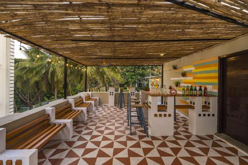 维沙卡帕特南Zostel Visakhapatnam (Vizag)的一间带长椅的餐厅和一间铺有瓷砖地板的酒吧