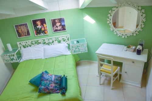 格拉维纳普利亚B&B Santa Sofia的一间卧室配有一张绿色的床、一张桌子和一面镜子