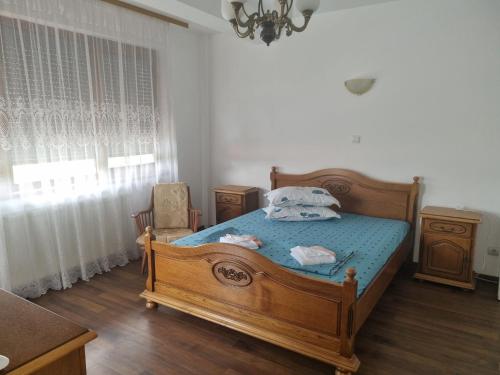 维纳斯Vila Orizont的一间卧室配有一张带蓝色床单的木床和窗户。