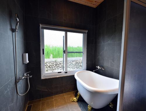埔里乐居日记民宿的带浴缸的浴室和窗户。