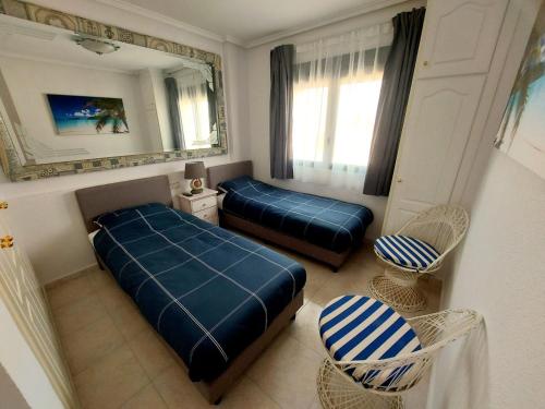 克萨达城Casa Prins 2-bed apartment with stunning views的一间卧室配有两张床、镜子和椅子