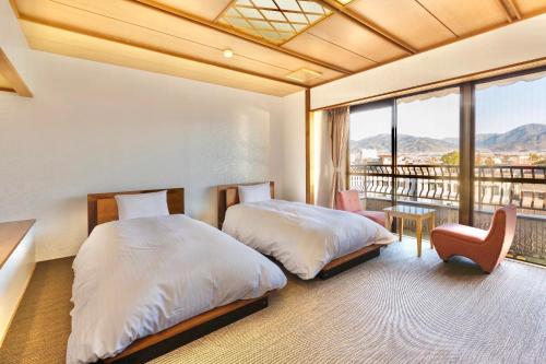 笛吹市Japanese Onsen Ryokan Kohakuen的一间带两张床的卧室和一个阳台