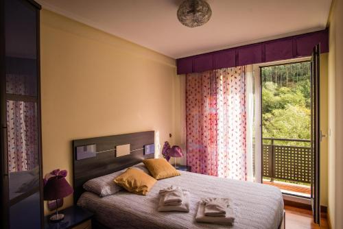 MendiondoCasa con terraza para 4 personas en Plentzia的一间卧室设有一张床和一个大窗户