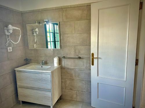 蒂亚斯Bungalows Doble UVE的一间带水槽、镜子和门的浴室