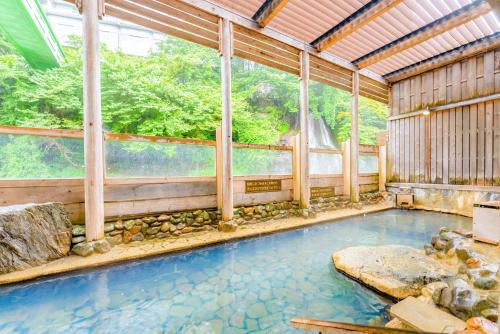 那须盐原市Ooedo Onsen Monogatari Hotel New Shiobara的一座带大窗户的房屋内的游泳池