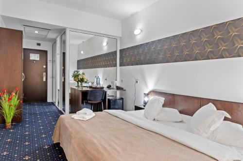 奥托佩尼奥托佩尼宪章酒店的酒店客房设有一张大床和一张书桌。