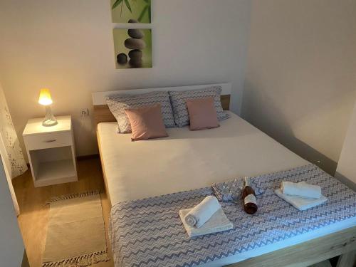 鲁马Apartman Popović的一间卧室配有一张床,提供两条毛巾和鞋子
