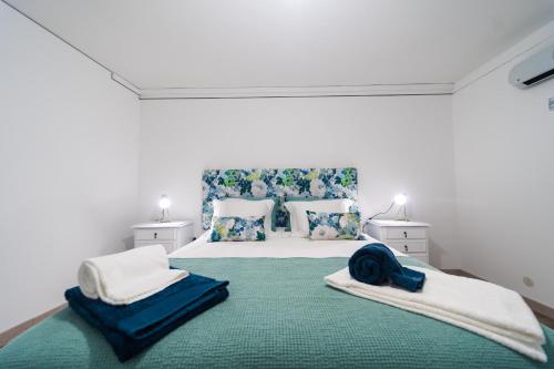 圣若昂达佩什凯拉Casa Milita的一间卧室配有一张带蓝白色枕头的大床