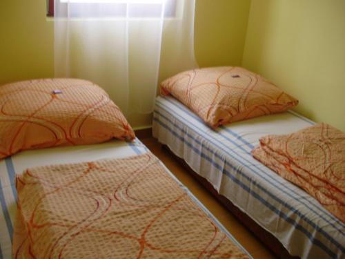 巴拉通雷勒Szatmári Vendégház的带窗户的客房内设有两张单人床。