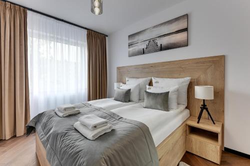 格但斯克Downtown Apartments Seaside Baltea Park & Parking的一间卧室配有一张大床和毛巾