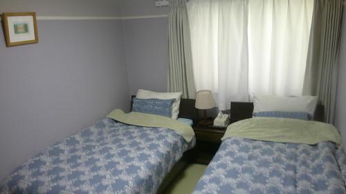 札幌旅の宿ていね的一间卧室设有两张床和窗户。