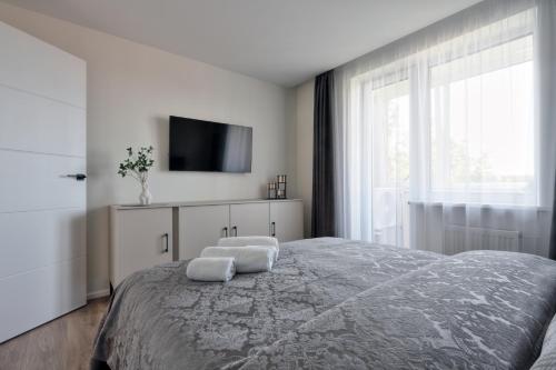 乌田纳Aušros apartamentai的一间卧室配有一张床,上面有两条毛巾