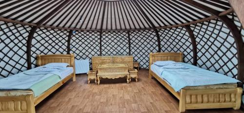 HujirtTalbiun Lodge的圆顶帐篷内带两张床和一张桌子的房间