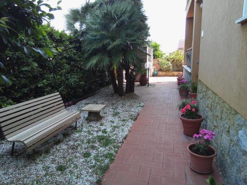 马西亚娜马里纳Appartamento Loretta的公园长凳,旁边是种有植物的砖砌走道