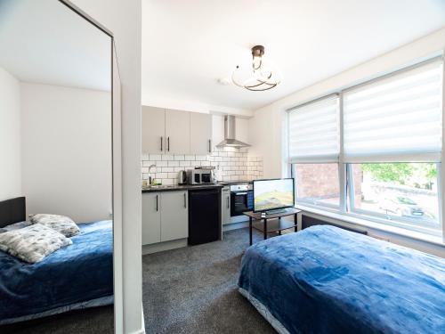 曼斯菲尔德Mansfield Town Centre Flats的一间卧室配有一张床,厨房配有窗户