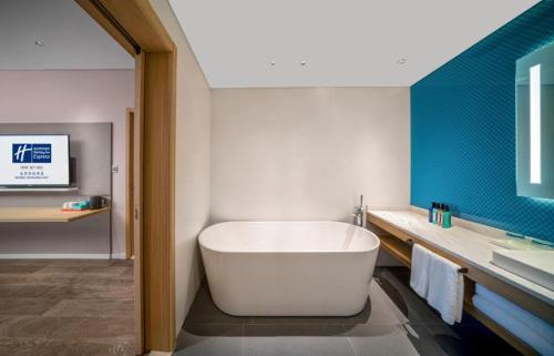 北京北京亦庄通明湖智选假日酒店的浴室配有白色浴缸和水槽