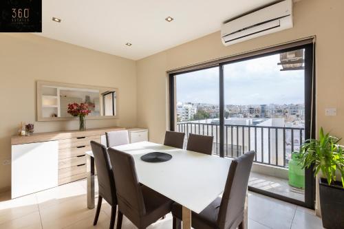 圣朱利安斯Beautiful, spacious 3BR home with private Balcony with 360 Estates的厨房以及带白色桌椅的用餐室。