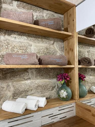 As Fontaiñas的浴室配有带毛巾的木制架子