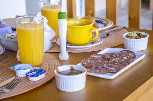 卡曼杜卡亚Pousada Sonho Meu的一张木桌,上面放着食物和橙汁