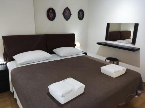 马科普隆A&J Apartments or Rooms athens airport的一间卧室配有一张带两个白色枕头的大床