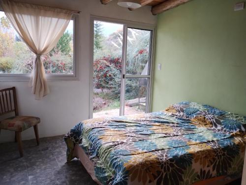 且乌塔Vista los Andes的卧室在窗户前配有一张床