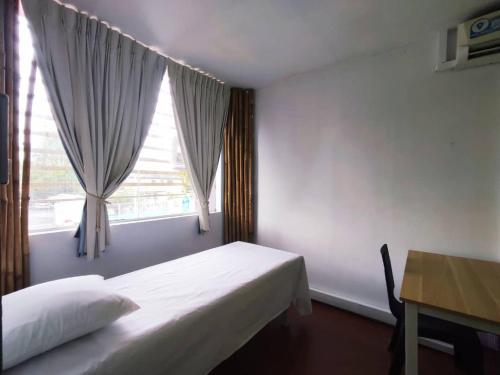 古晋Budget stay easy access to Timberland Medical Centre,Batu 3 Kuching By Natol-Hong Kong的一间卧室配有一张床、一张书桌和一个窗户。