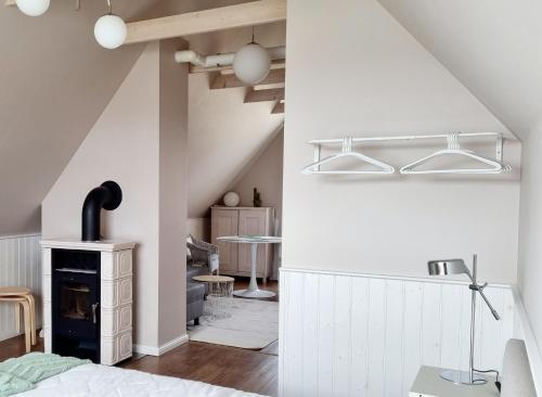 哈普萨卢马林赫姆公寓的卧室设有白色墙壁、壁炉和桌子。