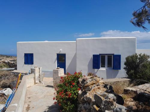 伊拉克利亚岛Spíti Catharina的白色的房子,有蓝色百叶窗和鲜花