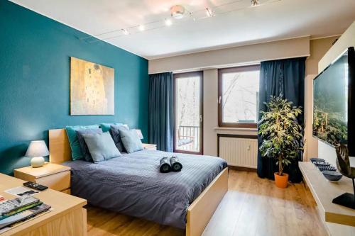蒙多夫莱班Homestay in a nice flat的一间卧室配有一张蓝色墙壁的床和一张书桌