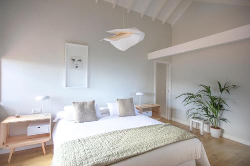 拉克鲁斯Hacienda Los Orovales的白色卧室配有床、桌子和植物