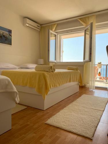 布雷拉House Bartulović的一间卧室设有两张床、一个窗户和一个地毯。