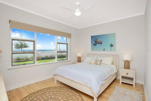 维克多港Saltys 4BRM Beachfront WIFI Pet Friendly的一间白色卧室,配有床和2个窗户