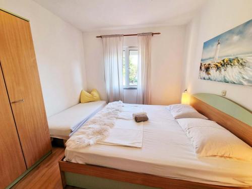 苏佩塔斯卡德拉加Apartment in Supetarska Draga with sea view, terrace, air conditioning, WiFi 4551-3的卧室设有一张白色大床和一扇窗户。