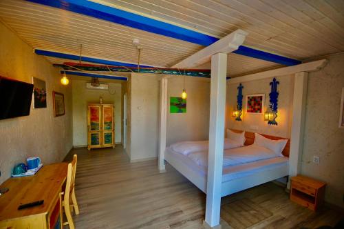 杜纳厄图德乔斯Nena Art Resort的一间卧室配有一张床、一张桌子和一张书桌