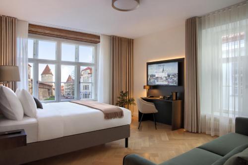 塔林Nunne Boutique Hotel的酒店客房设有一张床、一张书桌和窗户。