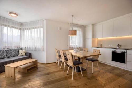 布鲁尼科Residence Stefansdorf的厨房以及带桌椅的起居室。