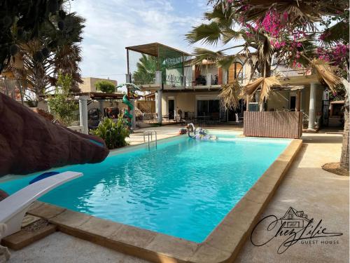 萨利波图尔Chez Lilie Maison d'hôtes à Saly的棕榈树度假村的游泳池