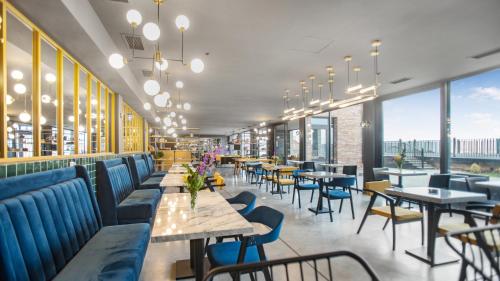 卡兹贝吉Hotel Memoir Kazbegi by DNT Group的餐厅设有桌椅和窗户。
