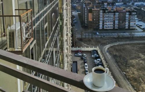 敖德萨Апартаменты на Марсельской, Кадорр, 4я Жемчужина的坐在大楼的顶端,喝杯咖啡