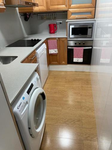 巴塞罗那Cozy Flat的厨房配有洗衣机和炉灶。