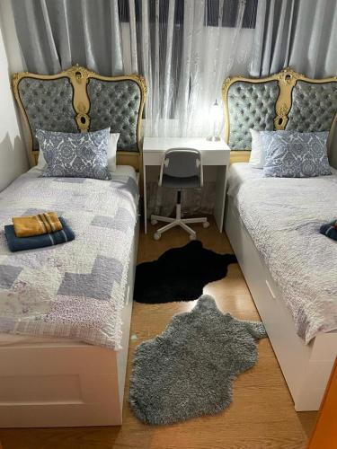 巴塞罗那Cozy Flat的一间卧室配有两张床、一张桌子和一张书桌。