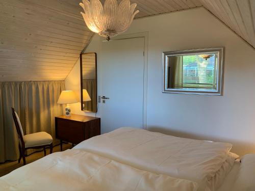 库拉萨Kollund Cottage的一间卧室配有一张床、一张书桌和一个窗户。